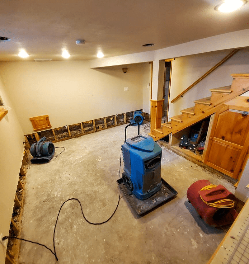 Basement under renovation with drying equipment.