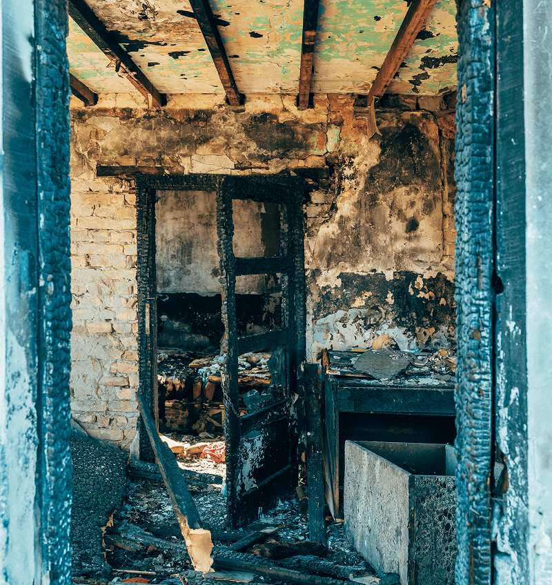 Burned interior with charred door and walls.