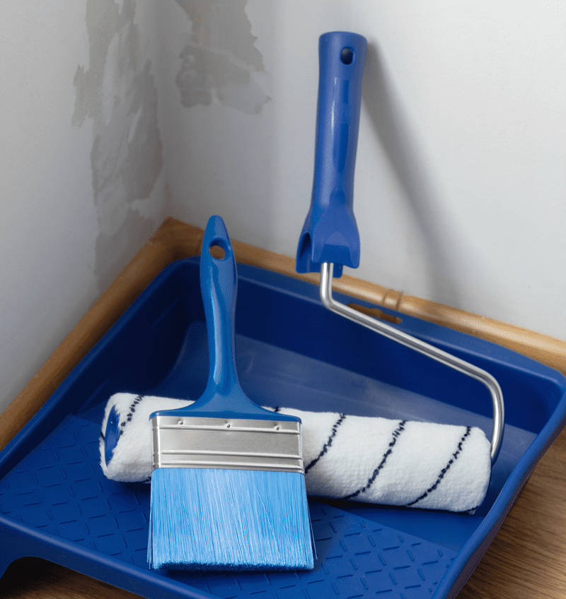 Paint roller and brush on tray.